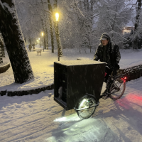 Gregor Hartz pushes a cargo bike through the snow.